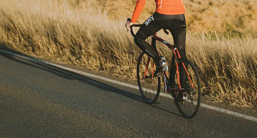 Person on a bike cycling on a paved road.