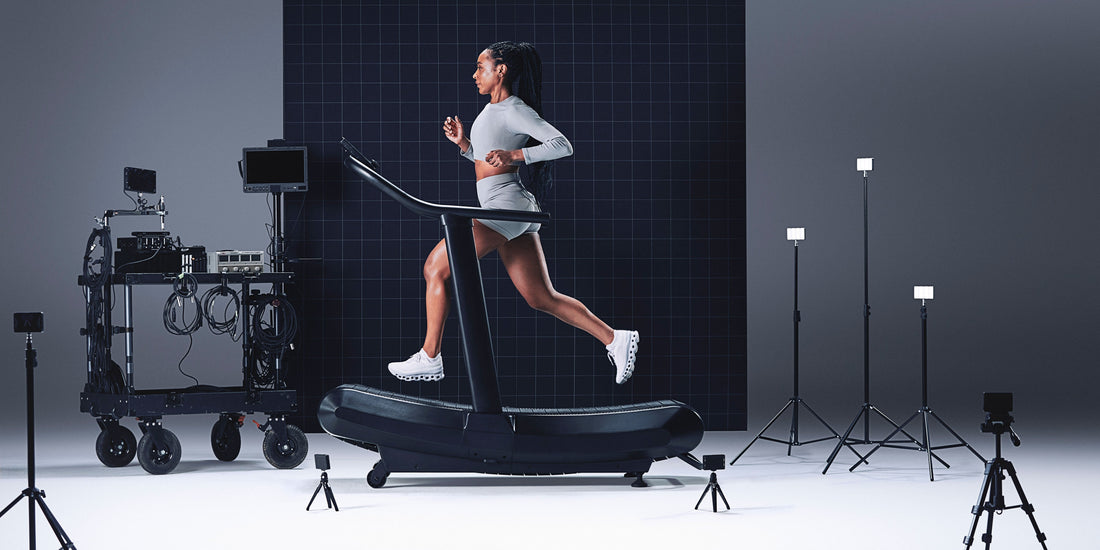 Person running on a treadmill in a studio setting with equipment and lighting.