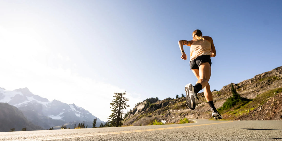 Person running on road up a hill while wearing Superfeet insole supports.