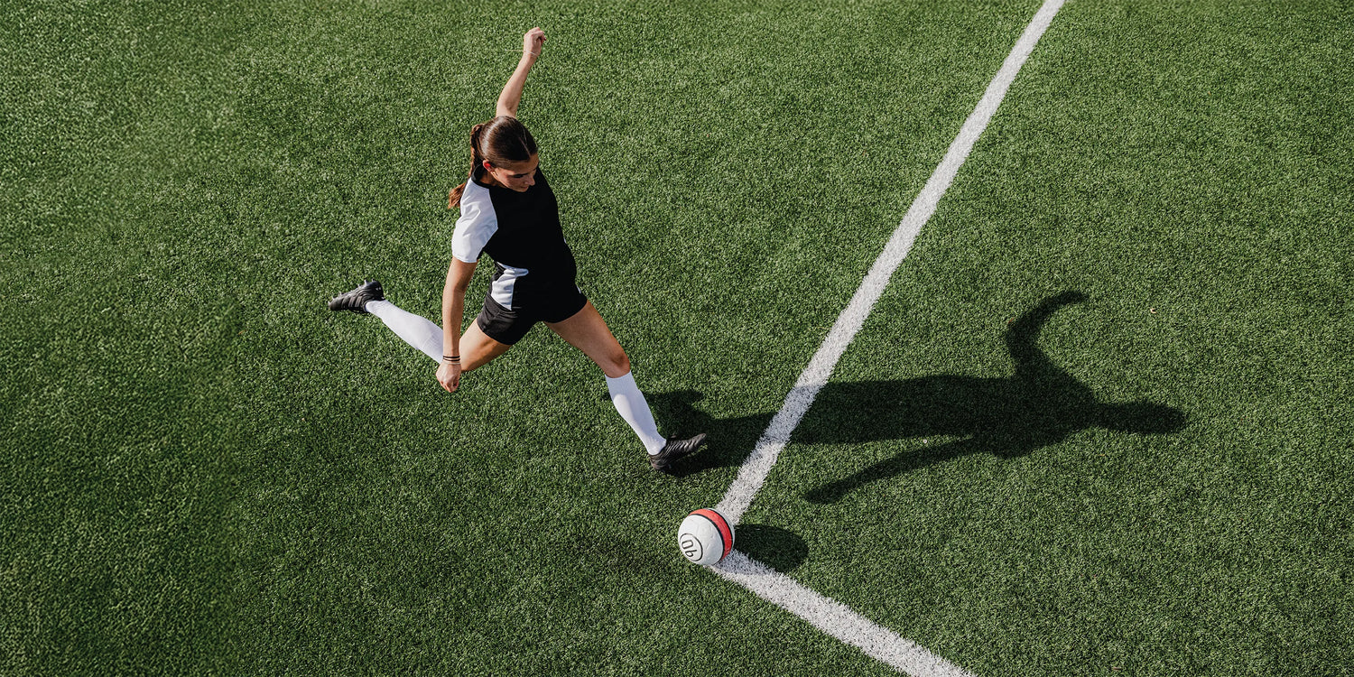 Soccer player taking a corner kick on a grass field