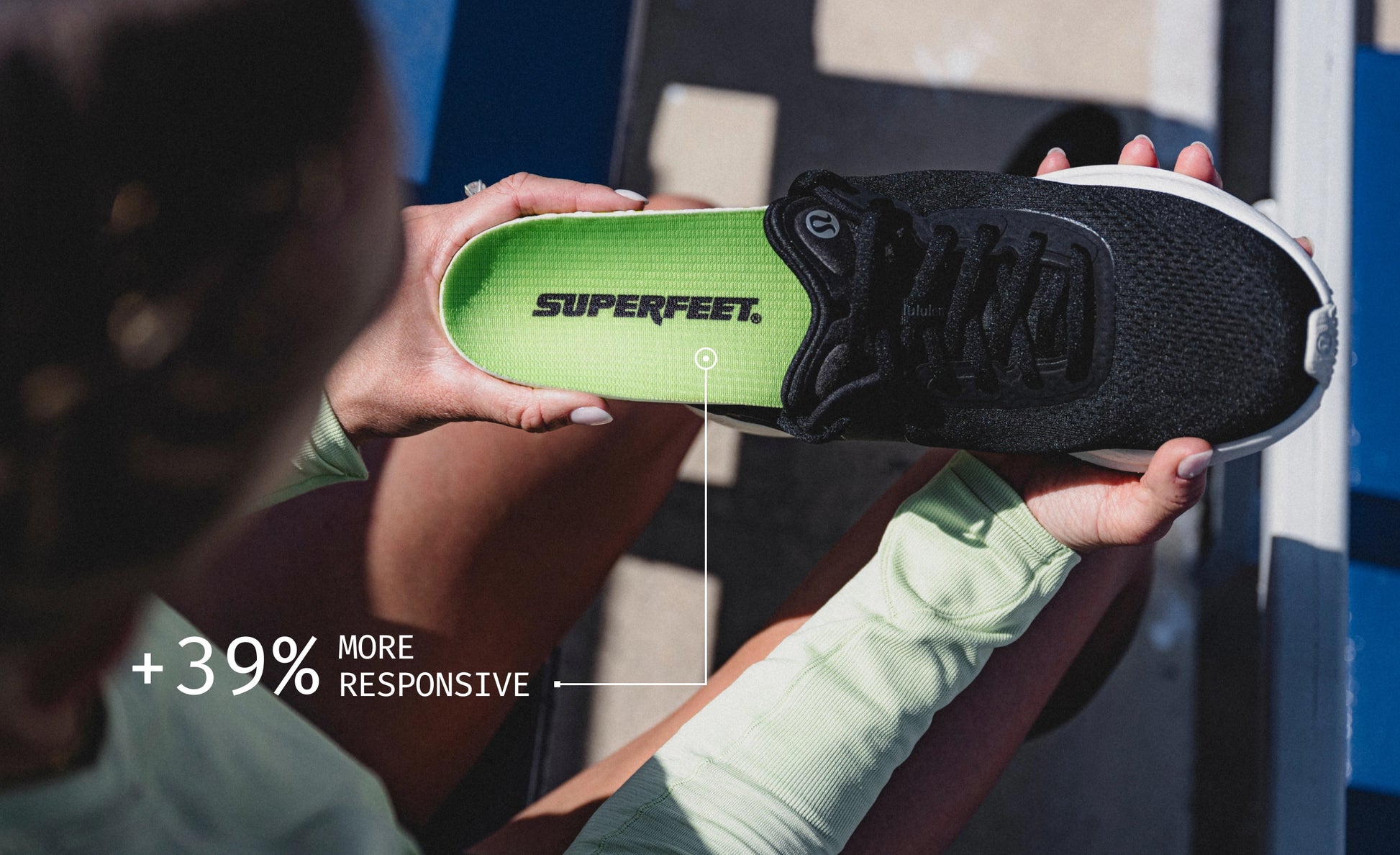 Person holding a black shoe and inserting the green Superfeet Run Pacer Elite insole. Text on image referencing +39% more responsive