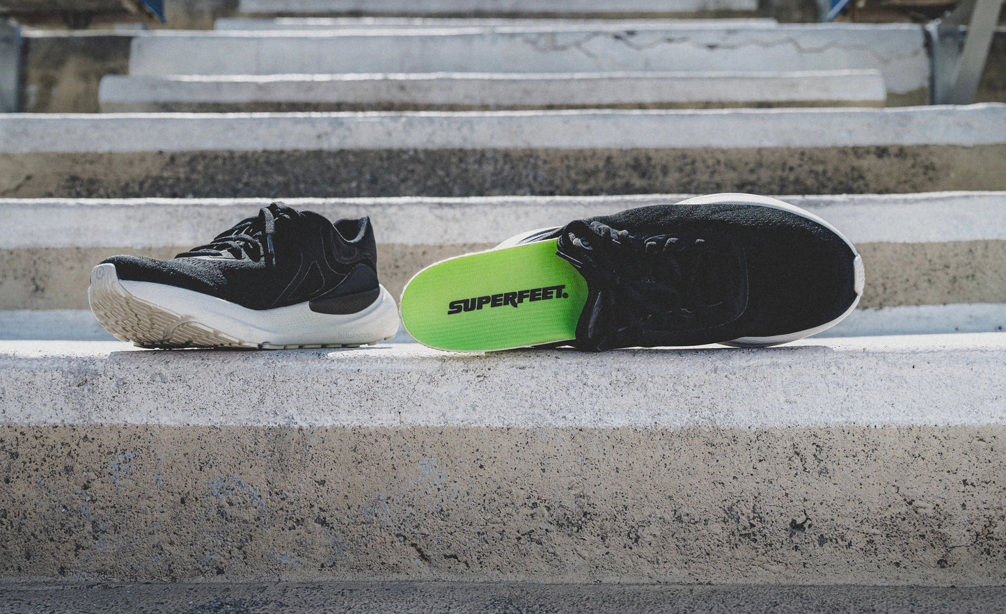 Superfeet's Run Pacer Elite insole sticking out of a black athletic shoe outside.