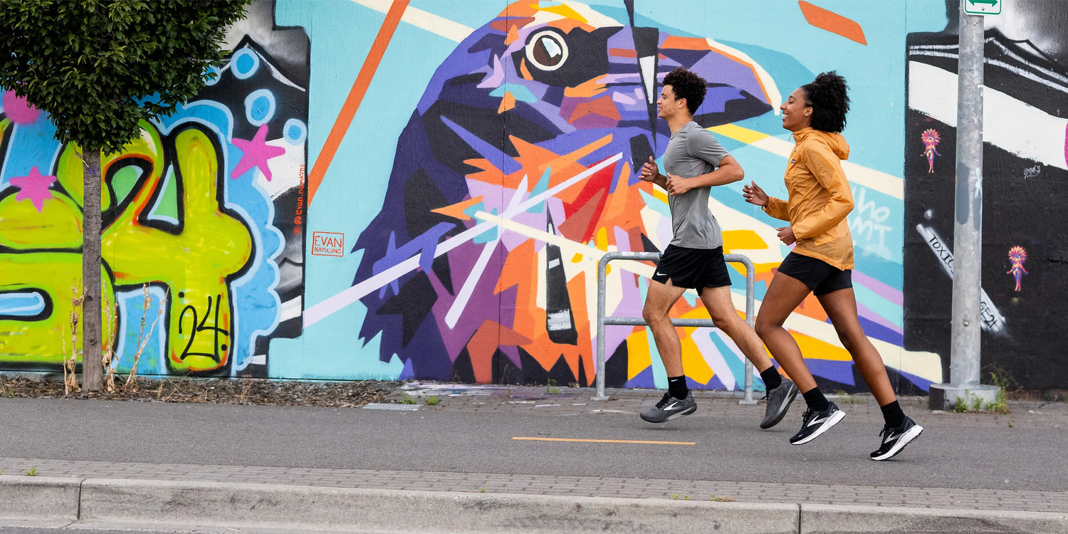 Man and woman running on pavement while wearing Superfeet insoles.