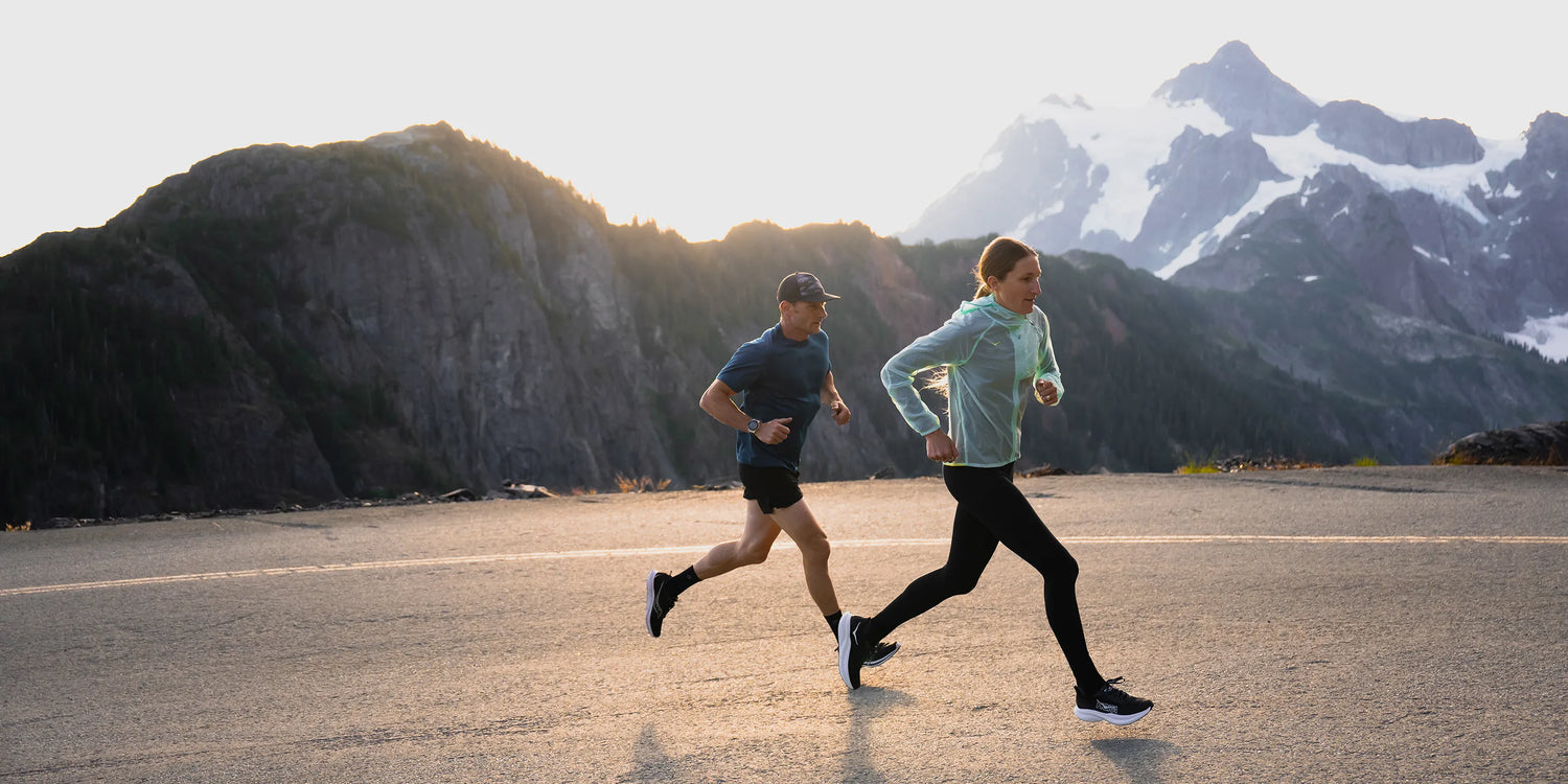 Man and woman on road running uphill while wearing Superfeet insoles.
