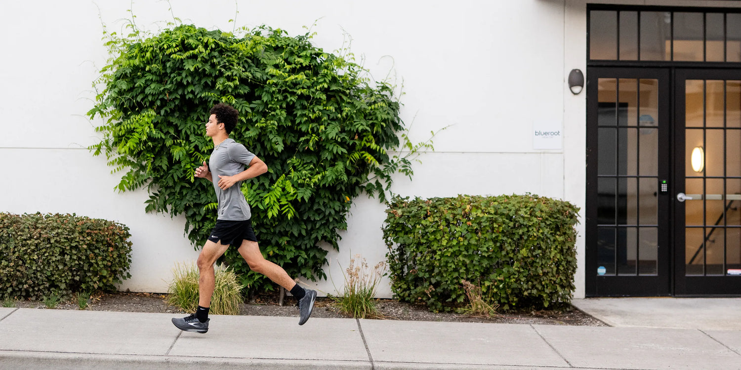 Man running up hill on a city sidewalk while wearing Superfeet insoles.