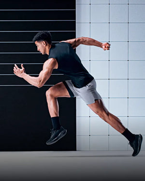 Studio image of a man running in front of a black and white background while wearing Superfeet insoles