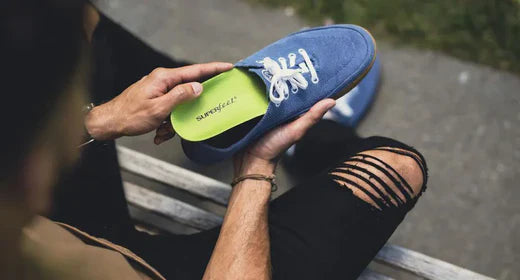 Person holding Superfeet insole and inserting into a shoe