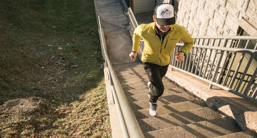 A man running up a set of stairs while wearing Supferfeet insoles.