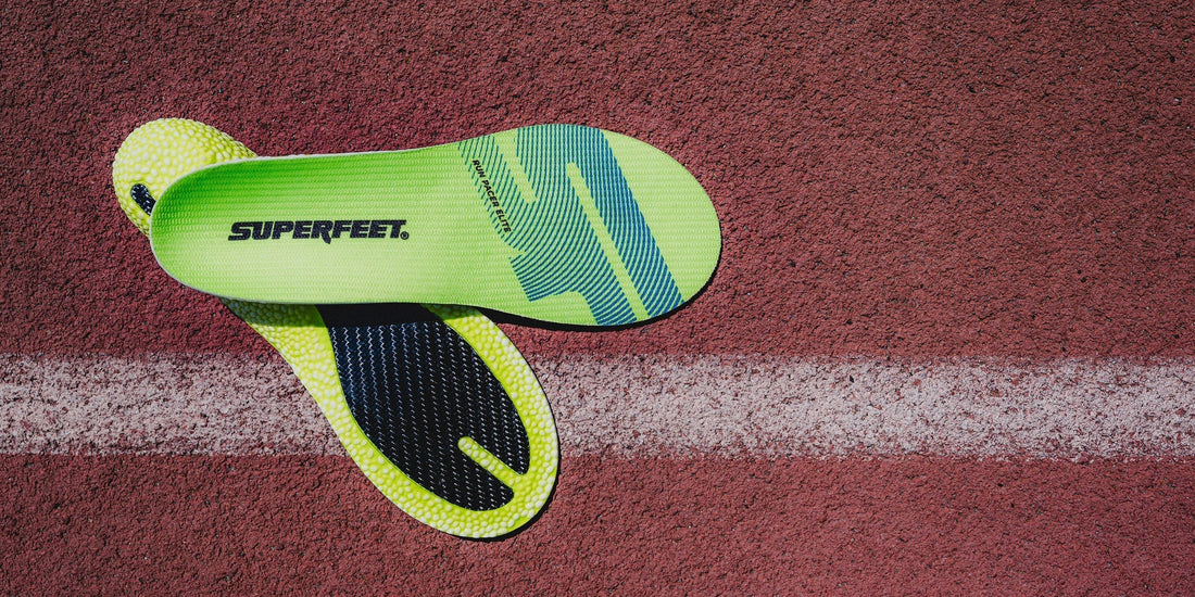 Superfeet branded lime green insoles on a track