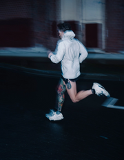 A blurry image of a person running outside at night. 