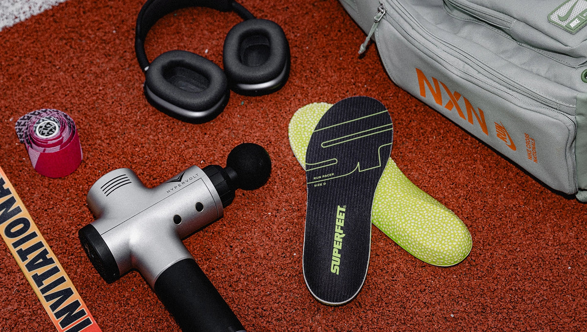 Superfeet's Run Pacer Insole laying on a track with various running equipment. 