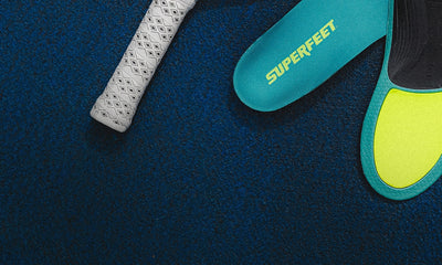 A close-up of Superfeet insoles on a blue court surface, 