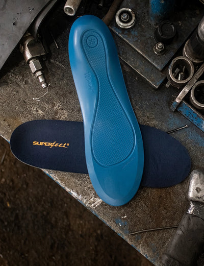 Superfeet's Work Memory Foam Insole laying on a work table with tools laying nearby. 