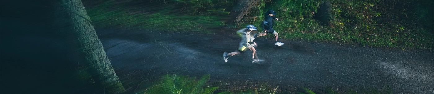 Birds eye view of a man running on wet pavement in the rain. 