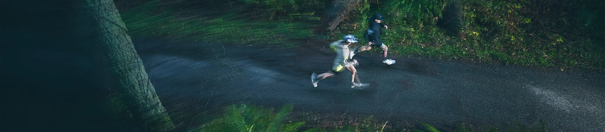 Birds eye view of a man running on wet pavement in the rain. 