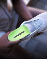 Close-up of a shoe with Superfeet insole being held, blurred background