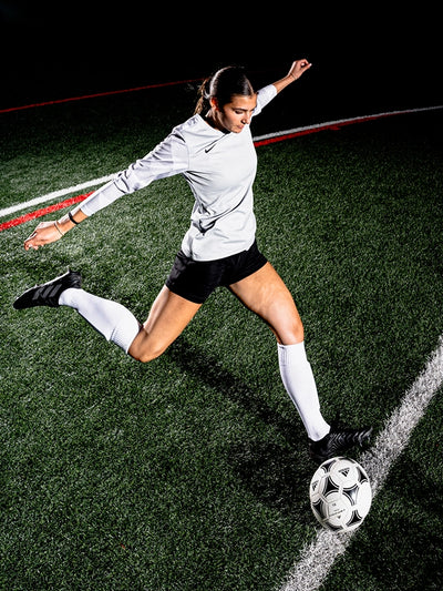 Soccer player in action on a field with a dark background