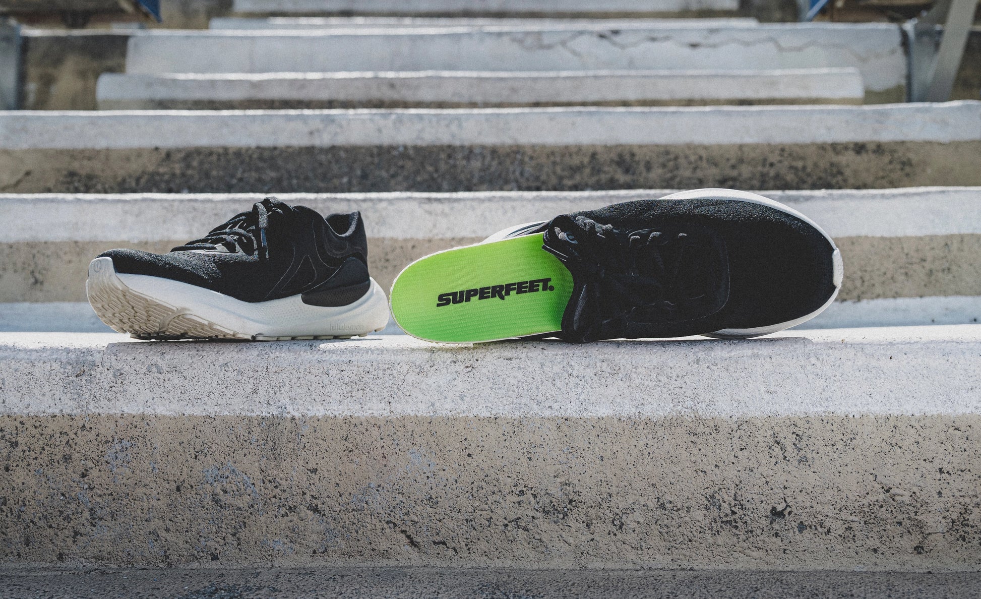 Superfeet's Run Pacer Elite insole sticking out of a black athletic shoe outside.