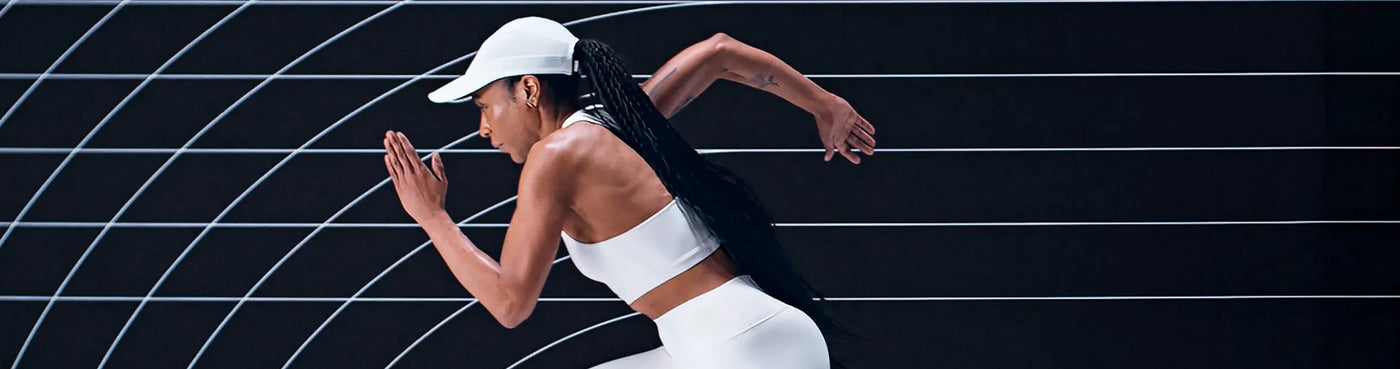 Woman in athletic wear running on a black and white striped background
