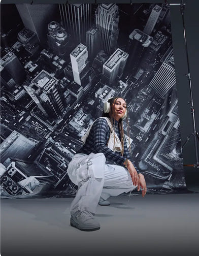 Person posing in front of a cityscape backdrop