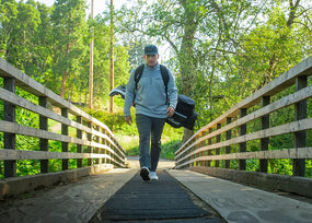 Man walking on golf course carrying his golf bag while wearing Superfeet insoles.