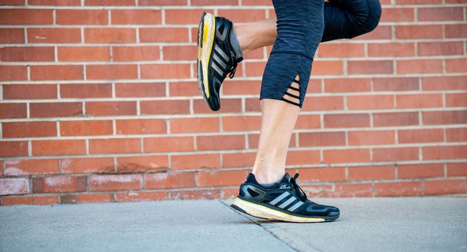 Woman's running shoes running on sidewalk