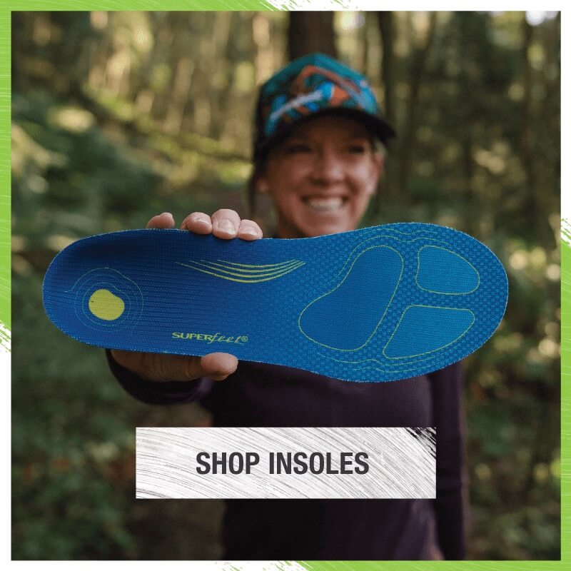 Woman in woods holding Superfeet Run Comfort Thin insole up to camera