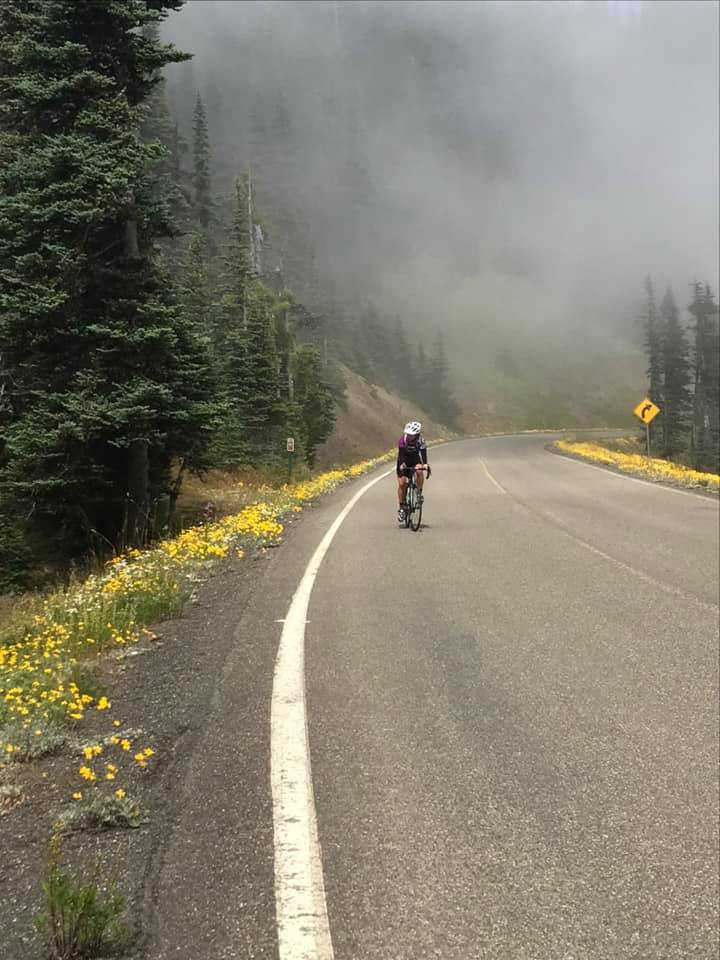 Christine McHugh road biking on a mountain highway
