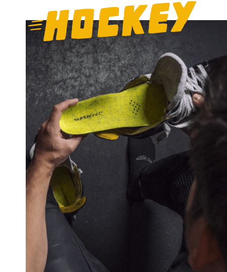 Over the shoulder view of a person putting a Superfeet Hockey Performance insole in their skate