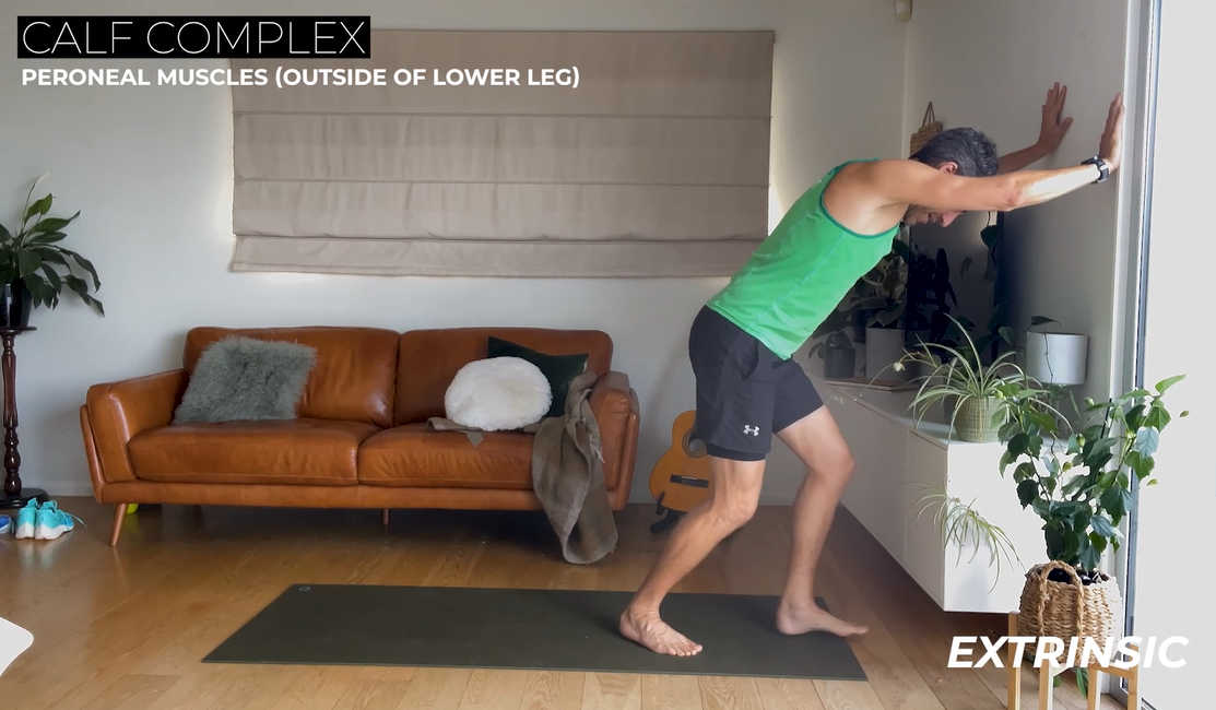 Runner doing stretches with graphic text overlay that says Calf Complex: Peroneal Muscles (outside of lower leg)