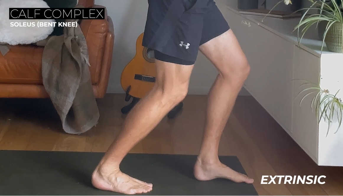 Runner doing a calf stretch with graphic text overlay that says Calf Complex: Soleus (Bent Knee)