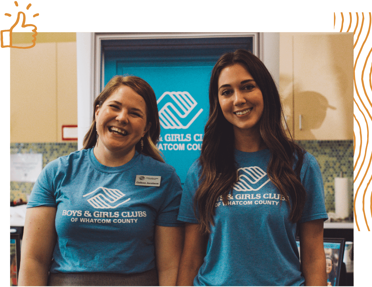 Two people with long hair smiling for the camera while wearing "Boys and Girls Club" t-shirts